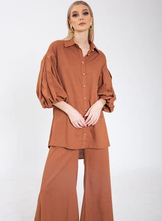 VL The Label by Virgos Lounge. Cropped wide leg trousers with chunky gold buttons and pockets in tan. Matching shirt available, with puffy sleeves and chunky gold buttons. Styled with Virgos Lounge Zoie Earrings and Virgos Lounge Shoes.